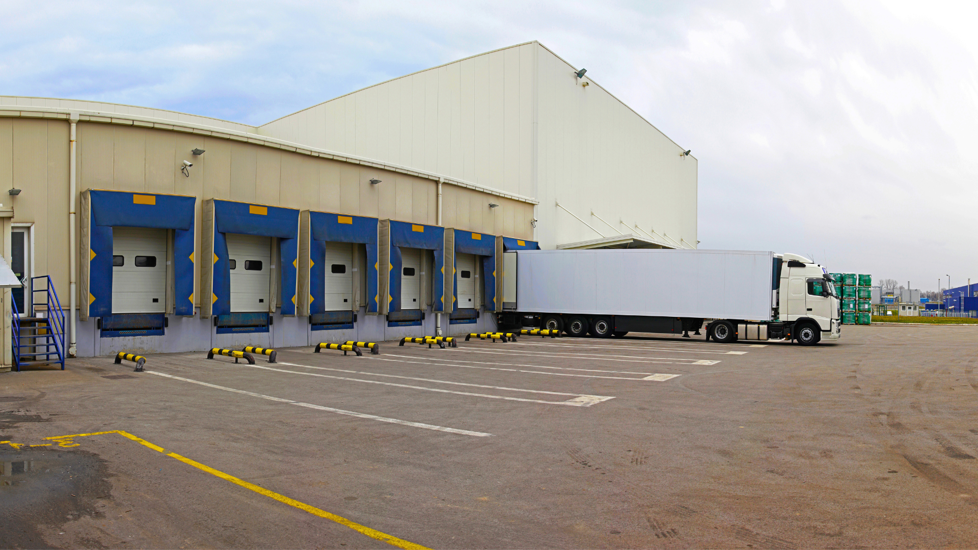 Shipping trucks in front of a gate in a truck yard