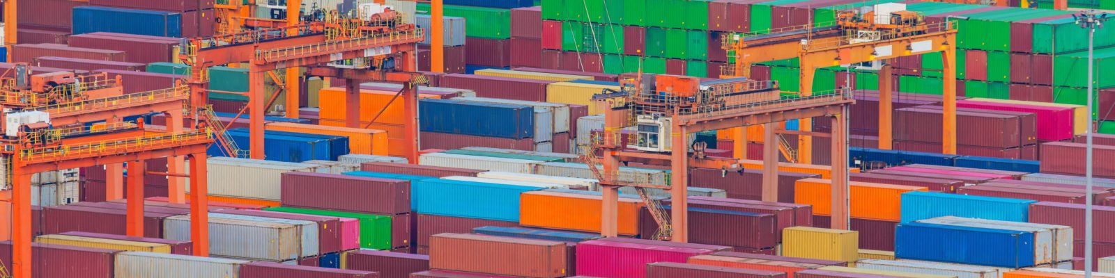 Extensive container stacks beneath cargo cranes at Shenzhen Port. Freight logistics, international shipping, container transportation and global trade operations.